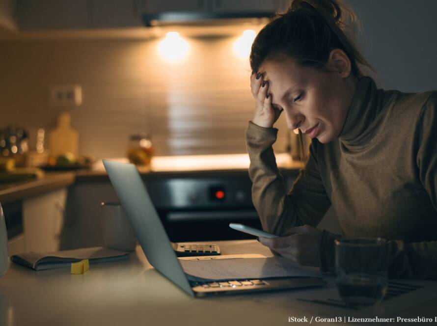 Bild zum ViewMed-Artikel "Stress und Erschöpfung: Wie berufsbegleitende Ansätze helfen können". Zu sehen: Frau am Küchentisch vor Laptop: traurig, gernevt