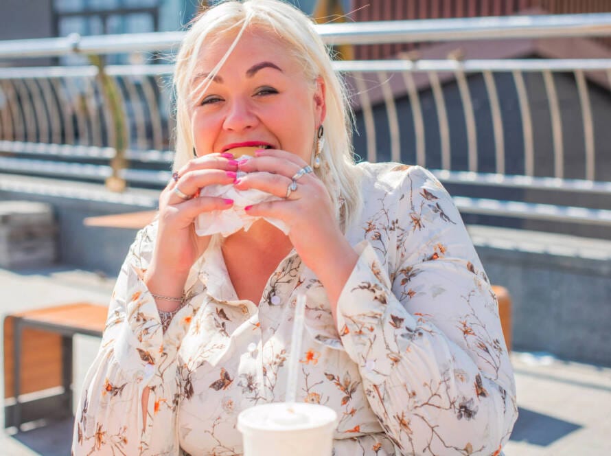 Frau isst Fastfood