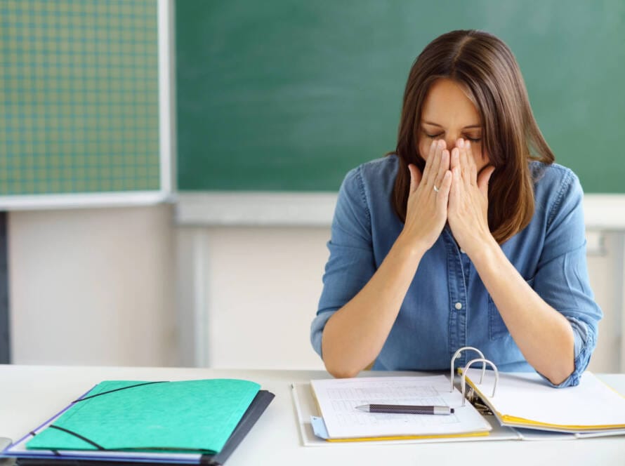 Lehrerin erschöpft am Pult