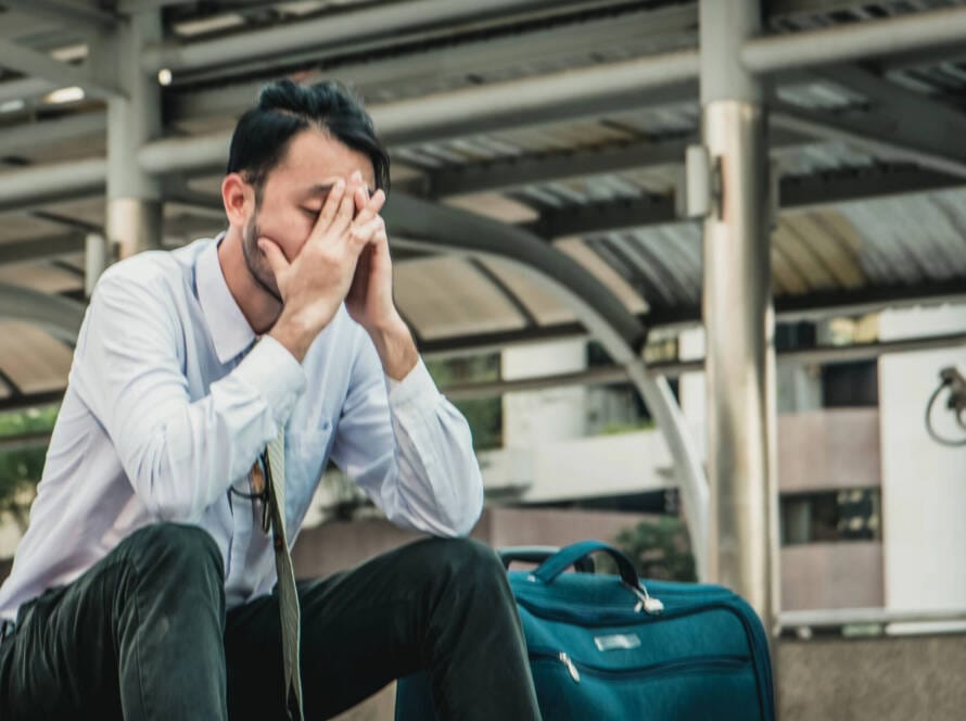 Mann asiatischer Herkunft gestresst am Flughafen.