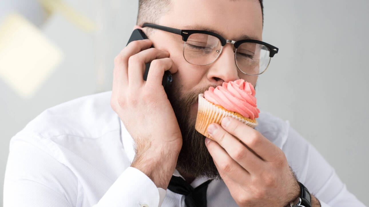 Business-Mann beißt in süßes Gebäck