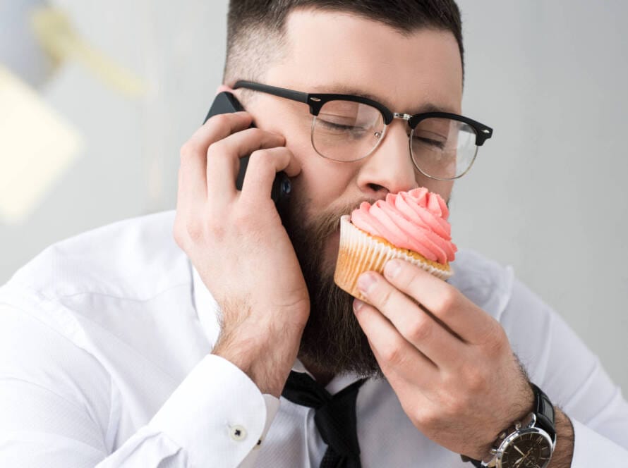 Business-Mann beißt in süßes Gebäck