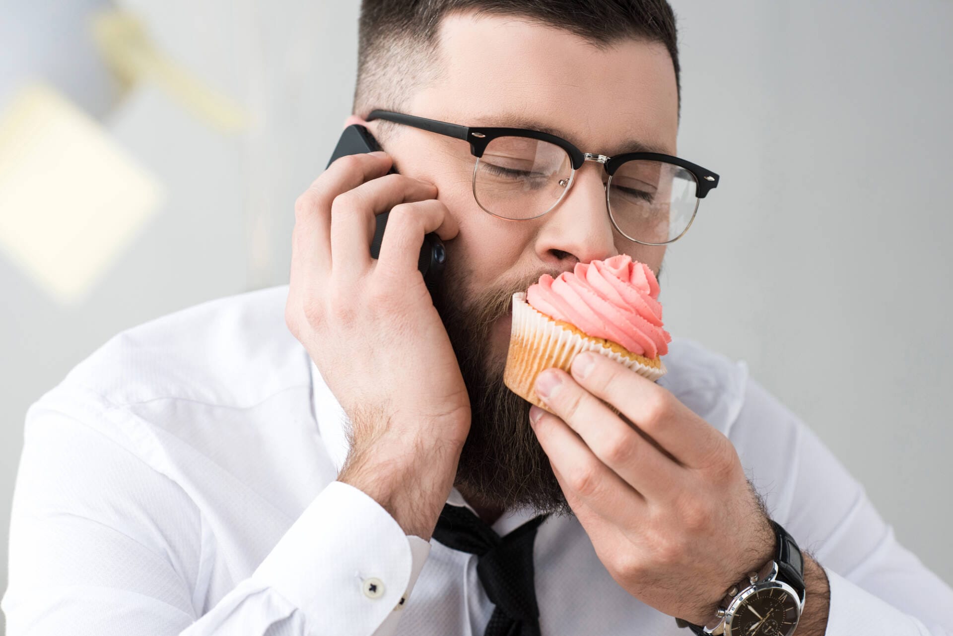 Business-Mann beißt in süßes Gebäck